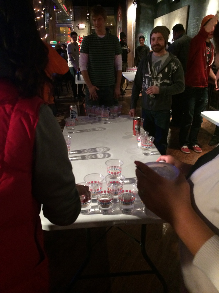 Beer pong players at the bar.
