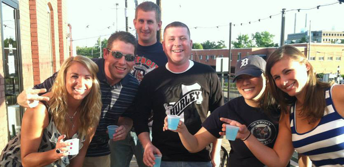 Friends outside on the patio holding colorful pudding shots.